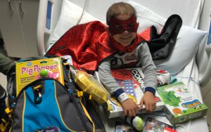 Child in Hospital Bed with Bag and Toys
