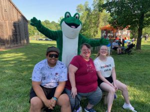 June Jam photo of 3 people and the Bags of Fun frog mascot