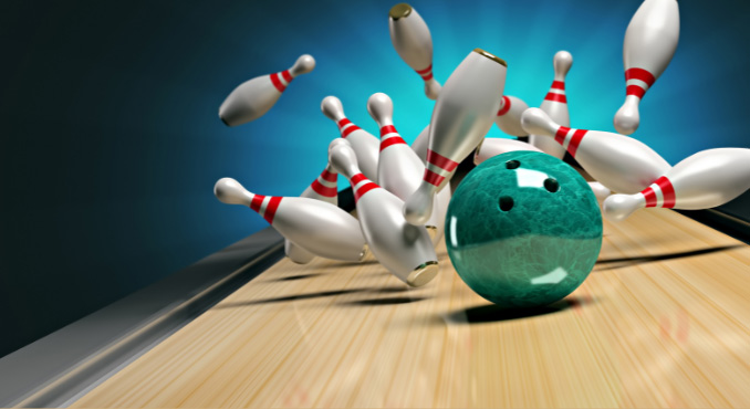 a green bowling ball hitting pins and the pins flying in different directions.