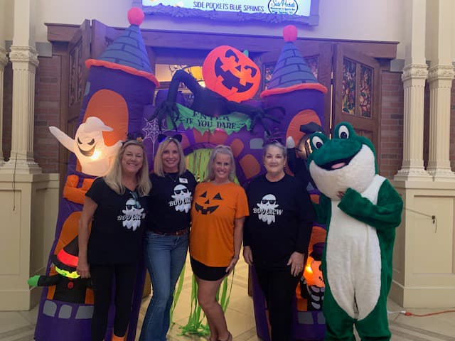 People taking a photo in front of an inflatable haunted castle with an entry way that says, Enter if you Dare